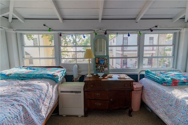 bedroom featuring carpet flooring, beam ceiling, and multiple windows