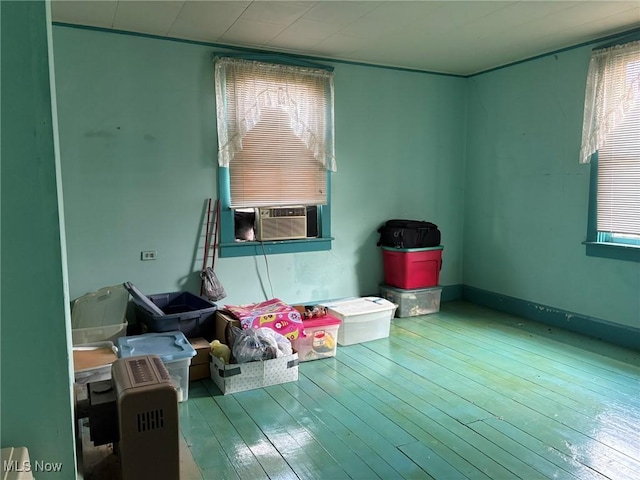 spare room with plenty of natural light, cooling unit, and hardwood / wood-style floors