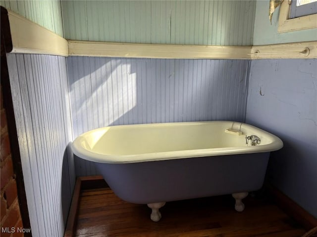 bathroom with a bath and hardwood / wood-style flooring