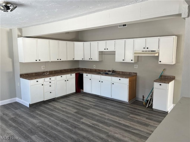 kitchen featuring dark hardwood / wood-style flooring, white cabinetry, and sink