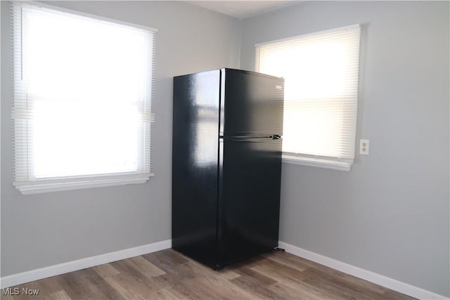 kitchen with black fridge and light hardwood / wood-style flooring