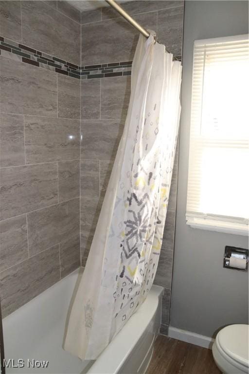 bathroom with hardwood / wood-style flooring, toilet, and shower / tub combo