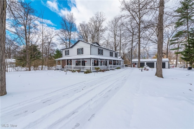 view of front of property with covered porch, a garage, and an outdoor structure