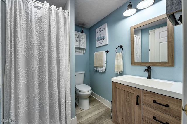 bathroom featuring vanity, hardwood / wood-style floors, a textured ceiling, and toilet