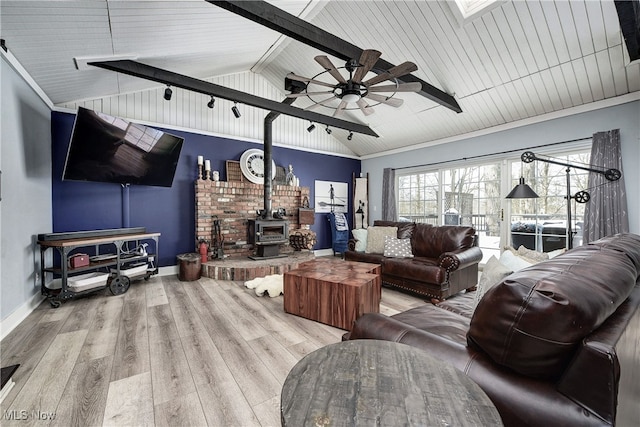 living room with a wood stove, ceiling fan, wooden ceiling, vaulted ceiling, and light wood-type flooring