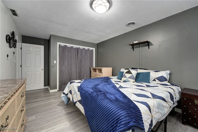 bedroom with a textured ceiling and dark hardwood / wood-style floors