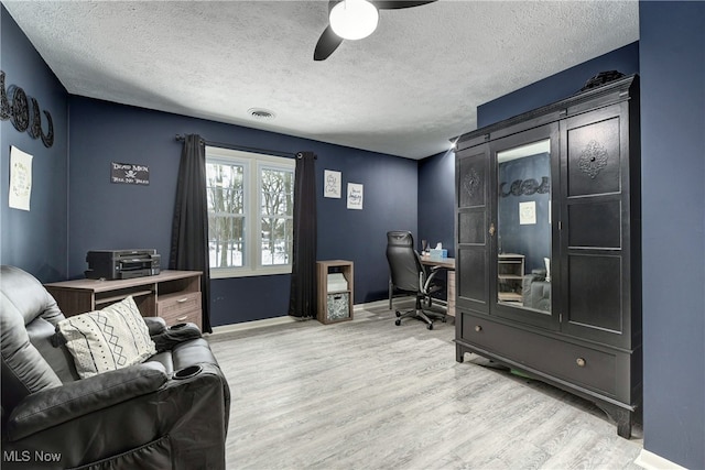 office featuring a textured ceiling, light hardwood / wood-style flooring, and ceiling fan