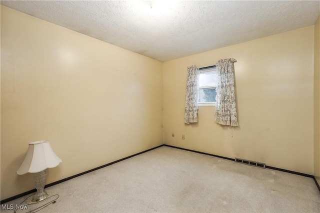 carpeted spare room with a textured ceiling