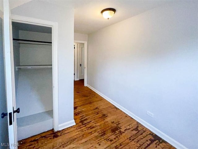 unfurnished bedroom with hardwood / wood-style floors and a closet