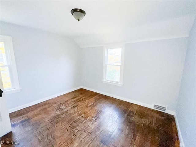 empty room with wood-type flooring and lofted ceiling