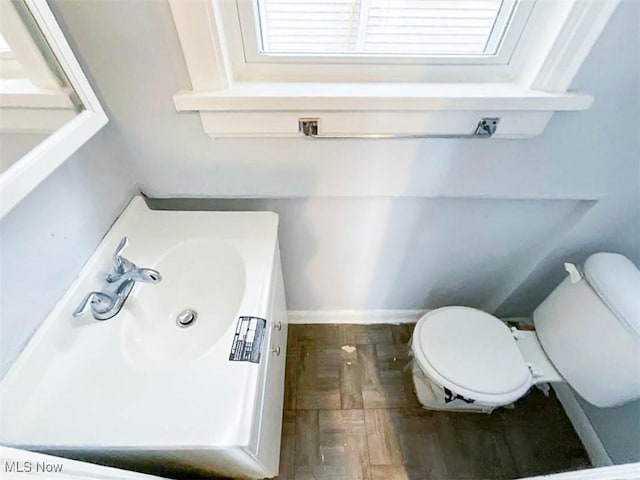 bathroom with vanity, toilet, and wood-type flooring