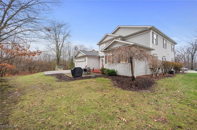 view of home's exterior with a lawn, a garage, and a patio