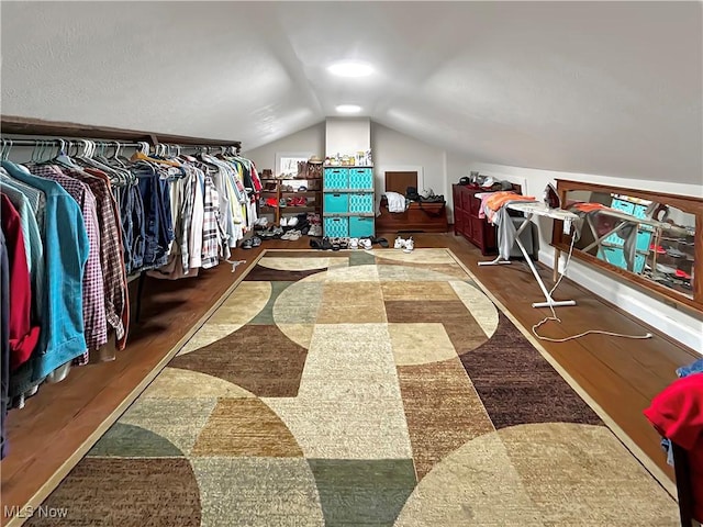 spacious closet featuring dark hardwood / wood-style floors and lofted ceiling