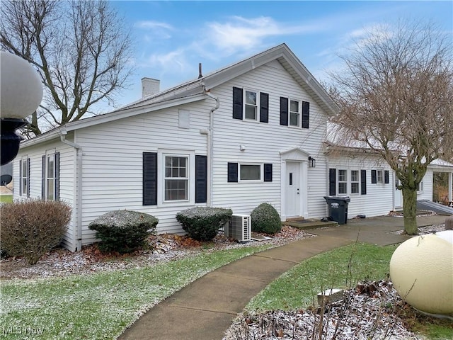 view of front of home with central air condition unit and a front yard