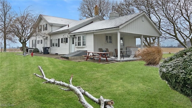 back of property with a lawn and a patio area