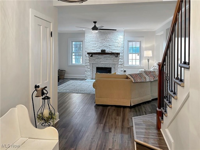 living room featuring a fireplace, dark hardwood / wood-style floors, ceiling fan, and ornamental molding