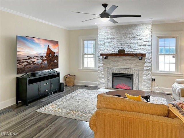 living room featuring a fireplace, a wealth of natural light, crown molding, and dark hardwood / wood-style floors