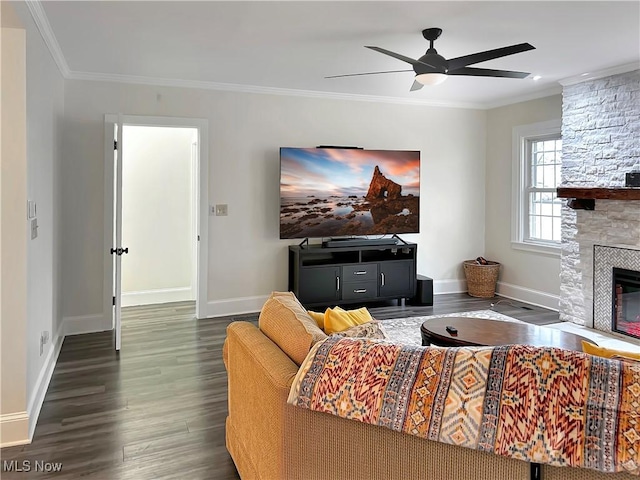 living room featuring crown molding, ceiling fan, a stone fireplace, and dark wood-type flooring