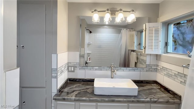 bathroom with a shower with curtain, decorative backsplash, and vanity