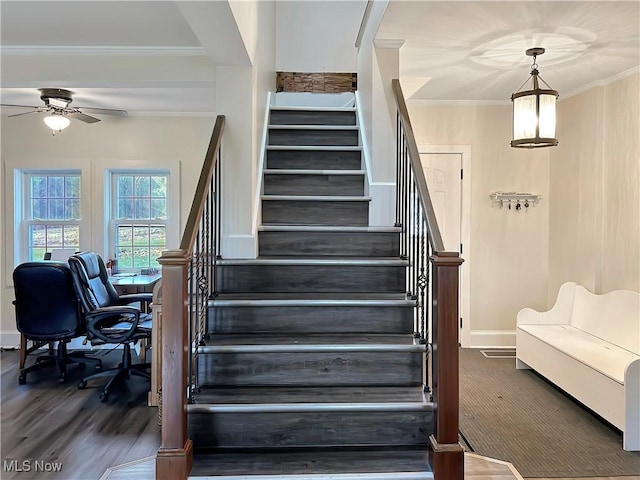 stairway with hardwood / wood-style floors, ceiling fan, and ornamental molding