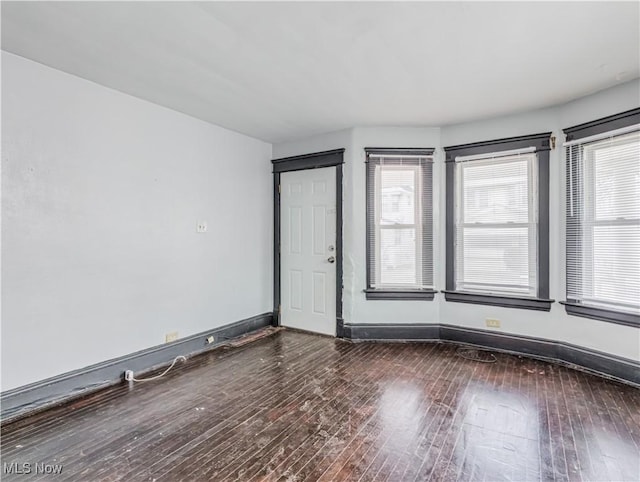 unfurnished room with dark wood-type flooring