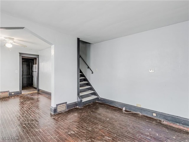 unfurnished room with ceiling fan and dark wood-type flooring