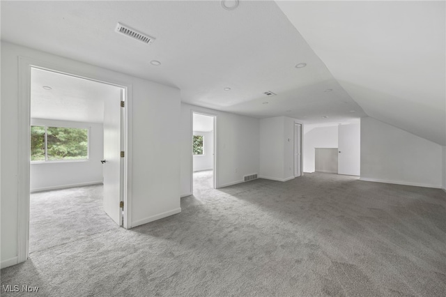 interior space with light carpet and vaulted ceiling