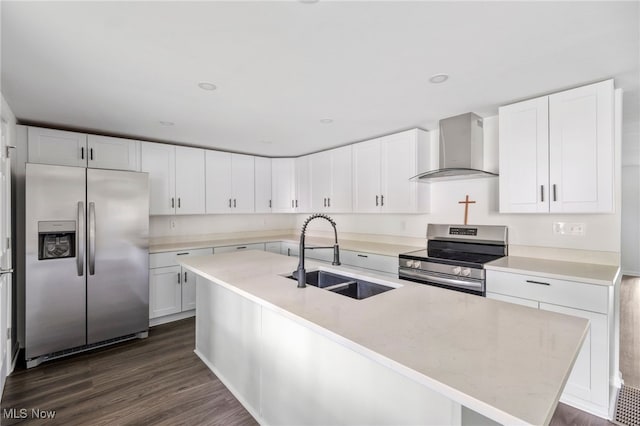 kitchen with appliances with stainless steel finishes, wall chimney exhaust hood, sink, a center island with sink, and dark hardwood / wood-style floors