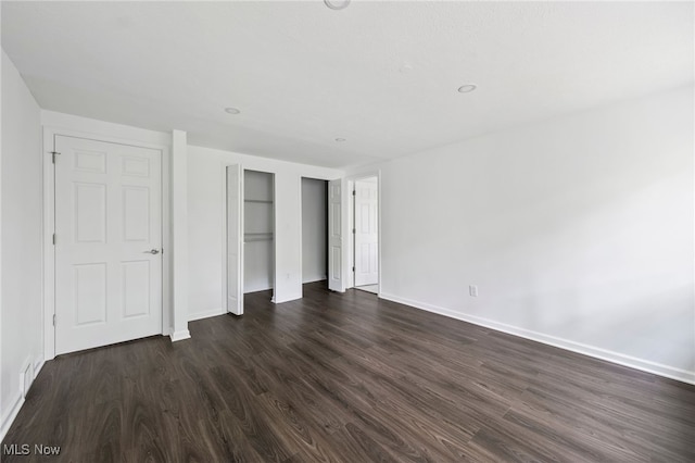 unfurnished bedroom with dark wood-type flooring