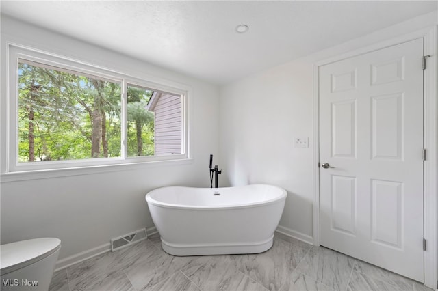 bathroom featuring a bathing tub and toilet