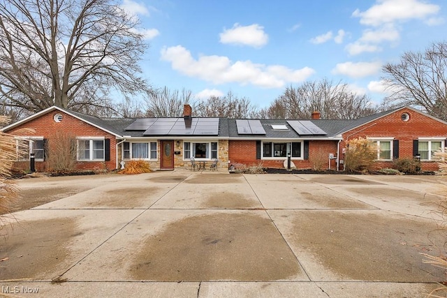 single story home featuring solar panels