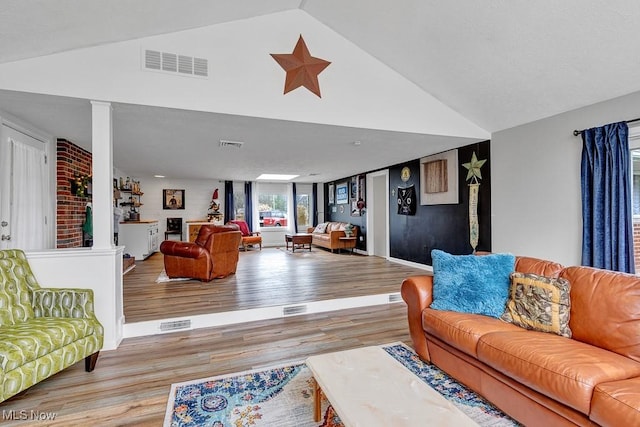 living room featuring lofted ceiling and light wood-type flooring