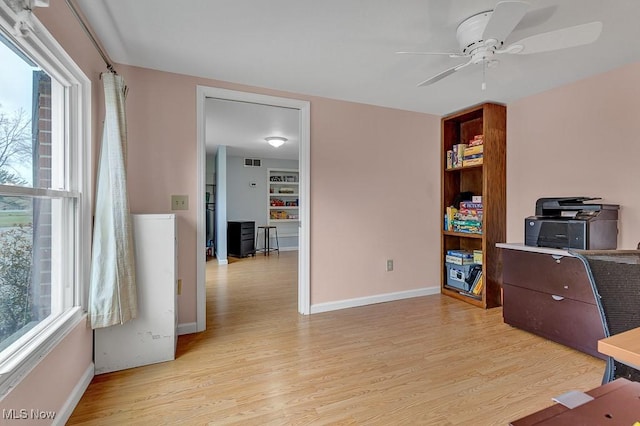 home office featuring ceiling fan, a healthy amount of sunlight, and light wood-type flooring