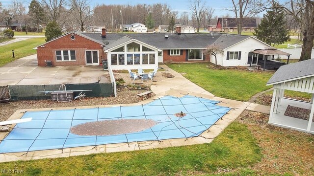 back of house featuring a yard, a patio, and a covered pool