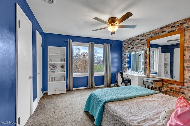 carpeted bedroom featuring ceiling fan and brick wall