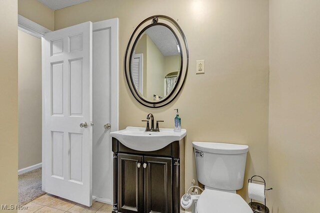 bathroom with tile patterned floors, vanity, and toilet