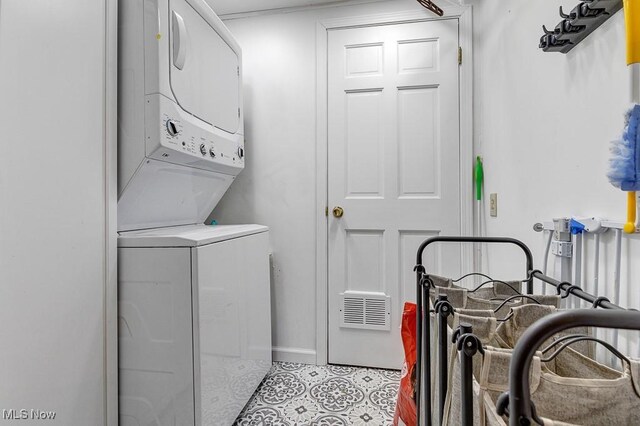 laundry area featuring stacked washer / drying machine