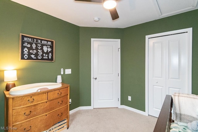 bedroom featuring a closet, light colored carpet, and ceiling fan