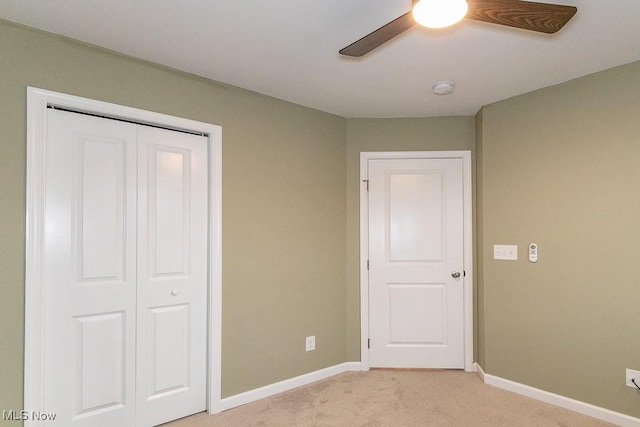 unfurnished bedroom featuring ceiling fan, a closet, and light colored carpet