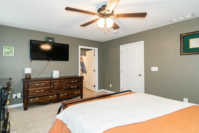 carpeted bedroom featuring a spacious closet and ceiling fan