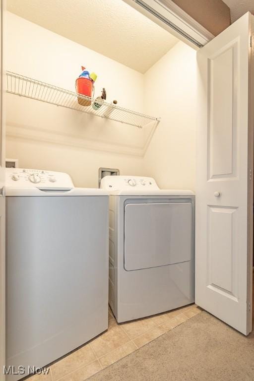 washroom with independent washer and dryer and light tile patterned floors