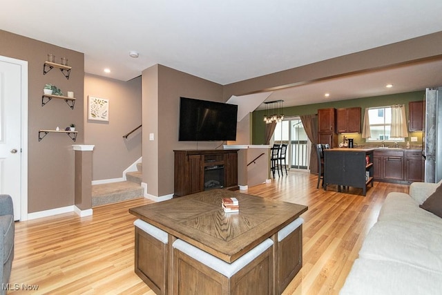 living room featuring a chandelier, light hardwood / wood-style flooring, and sink