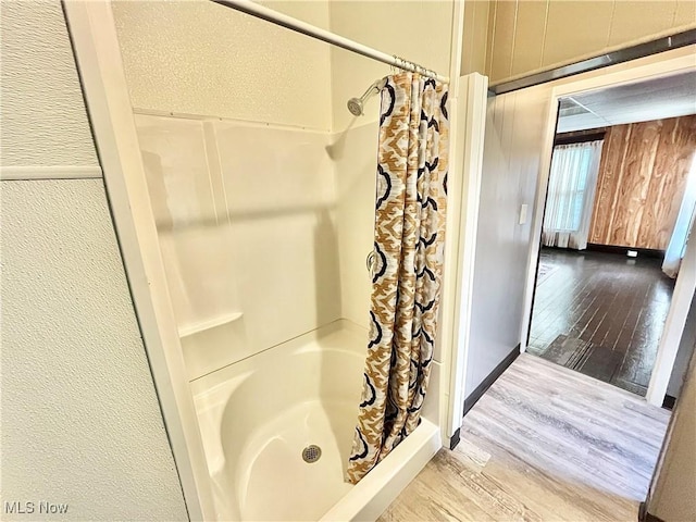 bathroom featuring hardwood / wood-style flooring and walk in shower