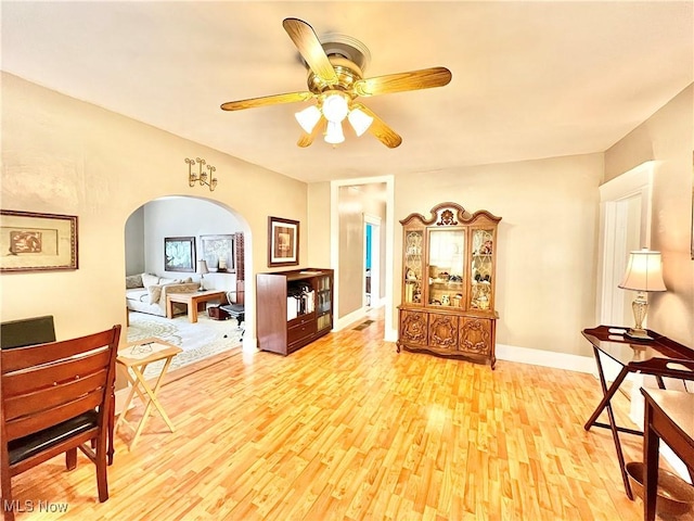 living area with ceiling fan and light hardwood / wood-style flooring