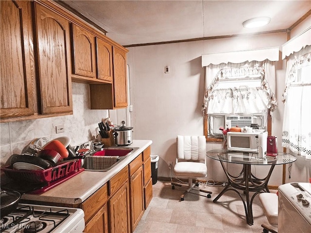 kitchen featuring sink, tasteful backsplash, white range, crown molding, and cooling unit