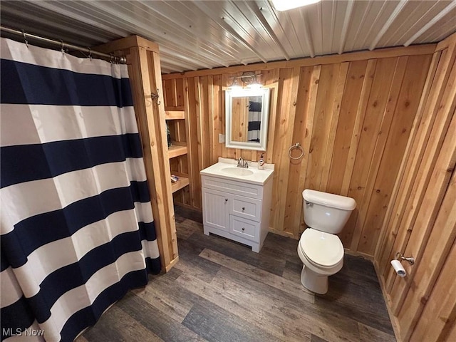 bathroom featuring wood walls, hardwood / wood-style floors, toilet, vanity, and wood ceiling