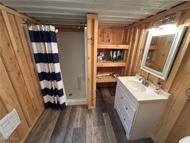 bathroom with a shower with curtain, wood walls, wood-type flooring, and vanity