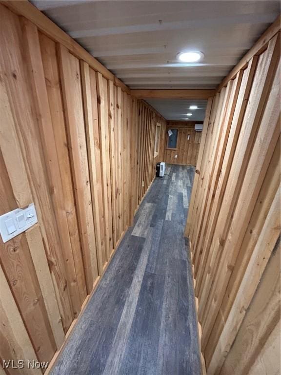 hall with dark hardwood / wood-style flooring and wooden walls