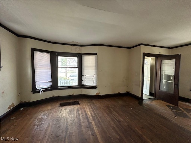 spare room featuring dark hardwood / wood-style floors and ornamental molding