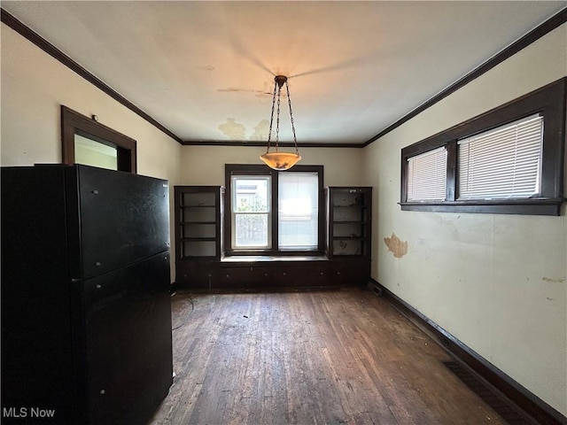 unfurnished dining area with dark hardwood / wood-style floors and ornamental molding